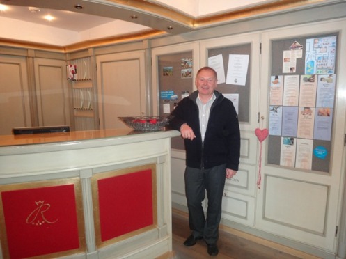 Erhard (na recepção do seu Hotel Ruebezahl), esposo da brasileira Giselle, o hoteleiro alemão que sonhou construir em Petrópolis, RJ, uma pista especial de patinação no gelo.